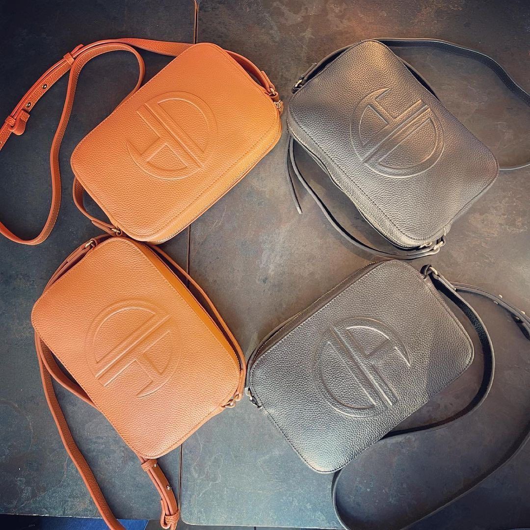 Four leather crossbody bags in orange and gray, embossed with a