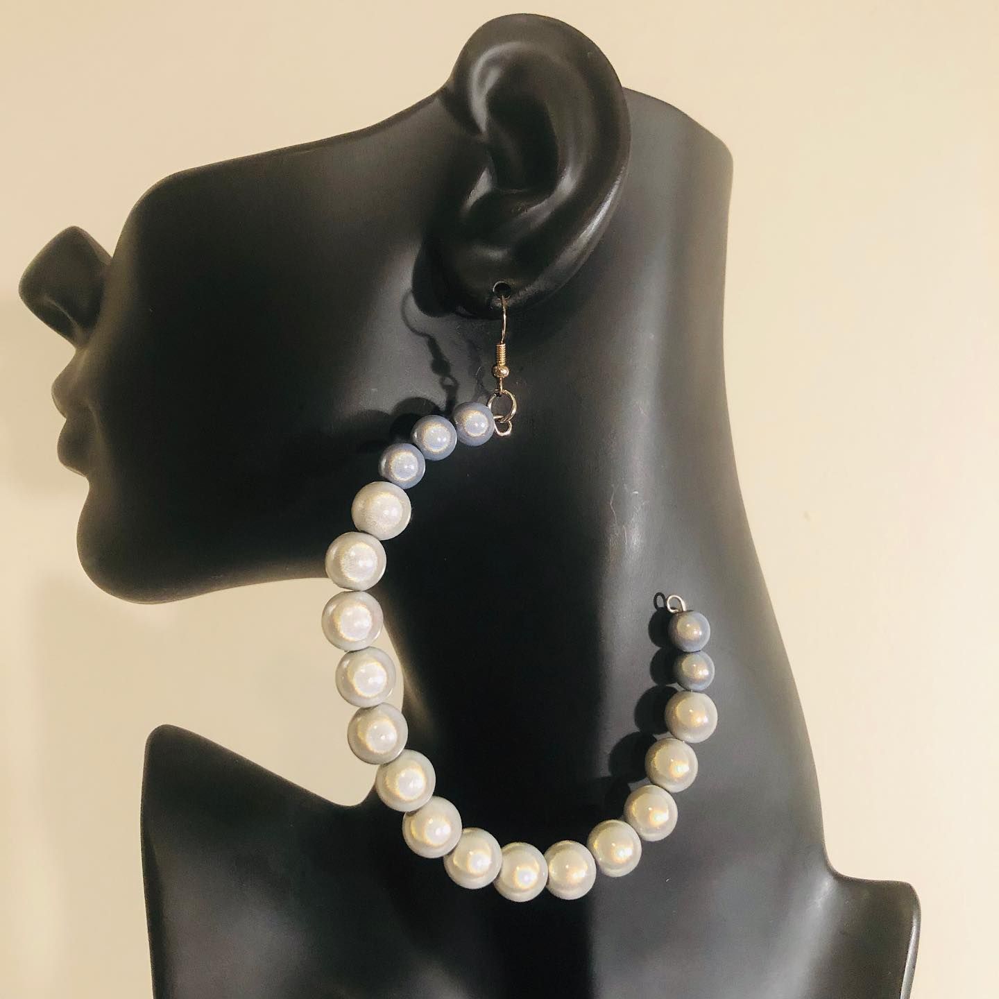Gray beaded hoop earrings on a black mannequin head.