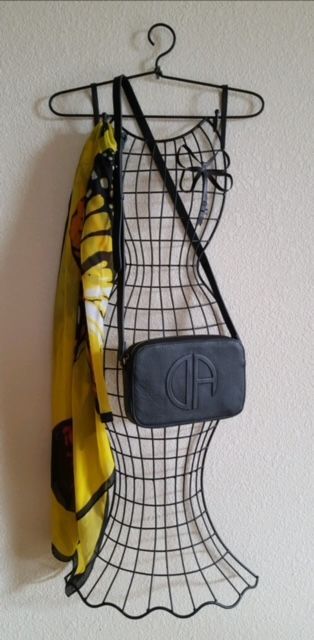 Wire dress form hanger with black purse and yellow scarf.