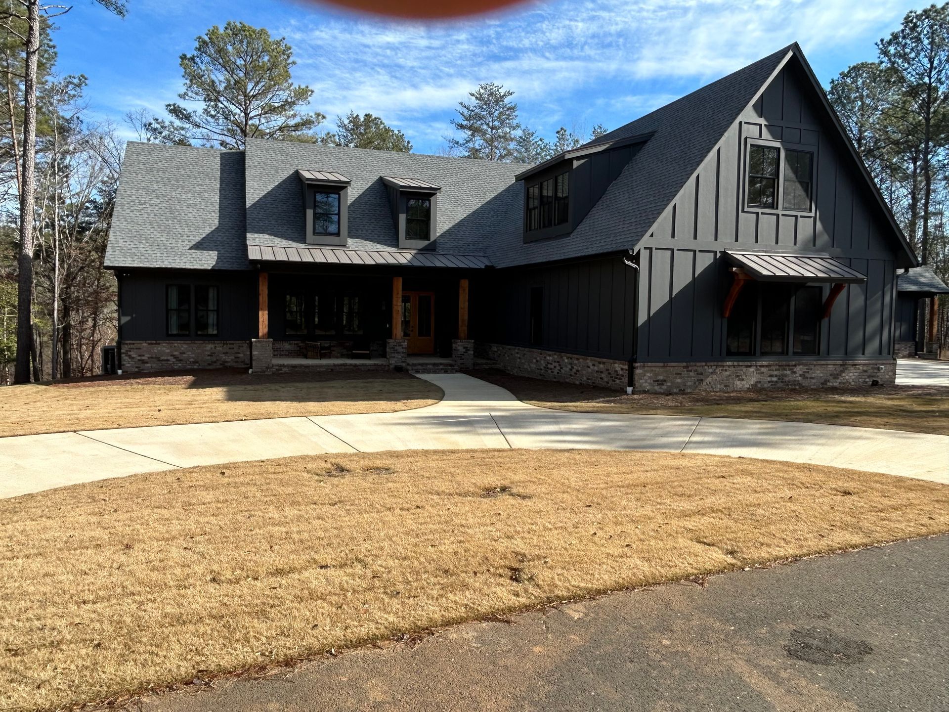 A man is painting a window on the side of a house.