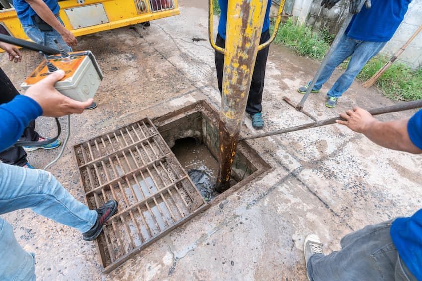 Workers Standing Around a Drain Cover — Hydro Excavation on the Sunshine Coast, QLD