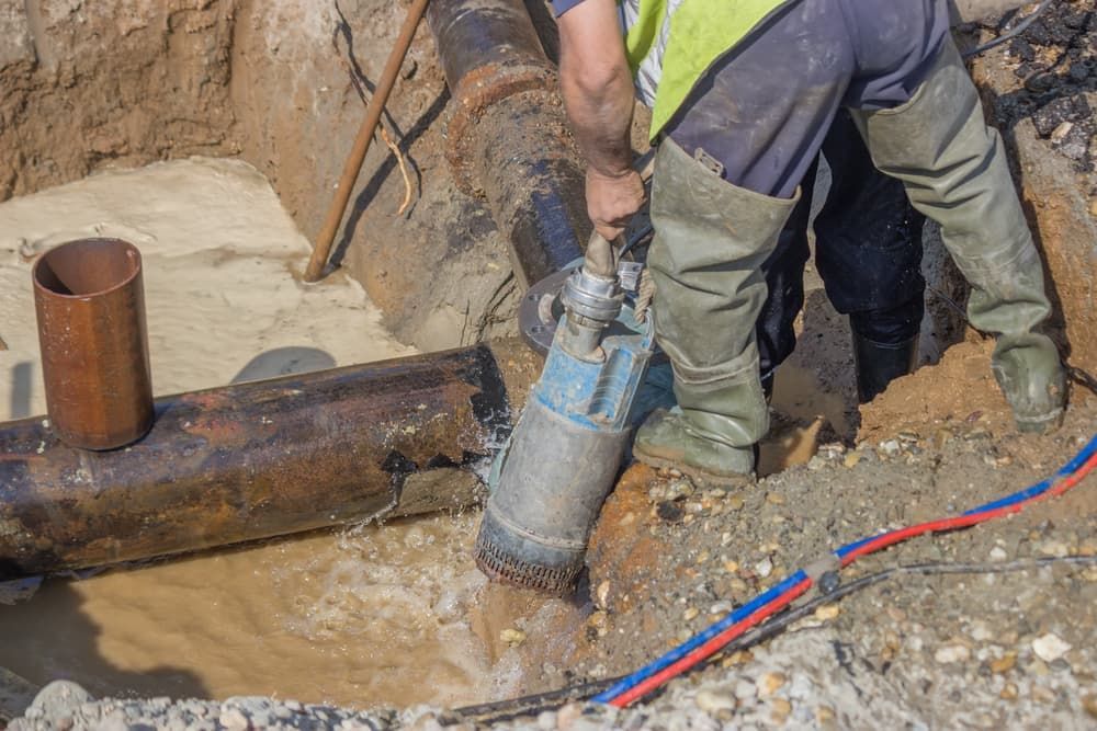 Worker Using a Hydro Vacuum to Remove Water From a Trench — Hydro Excavation on the Sunshine Coast, QLD