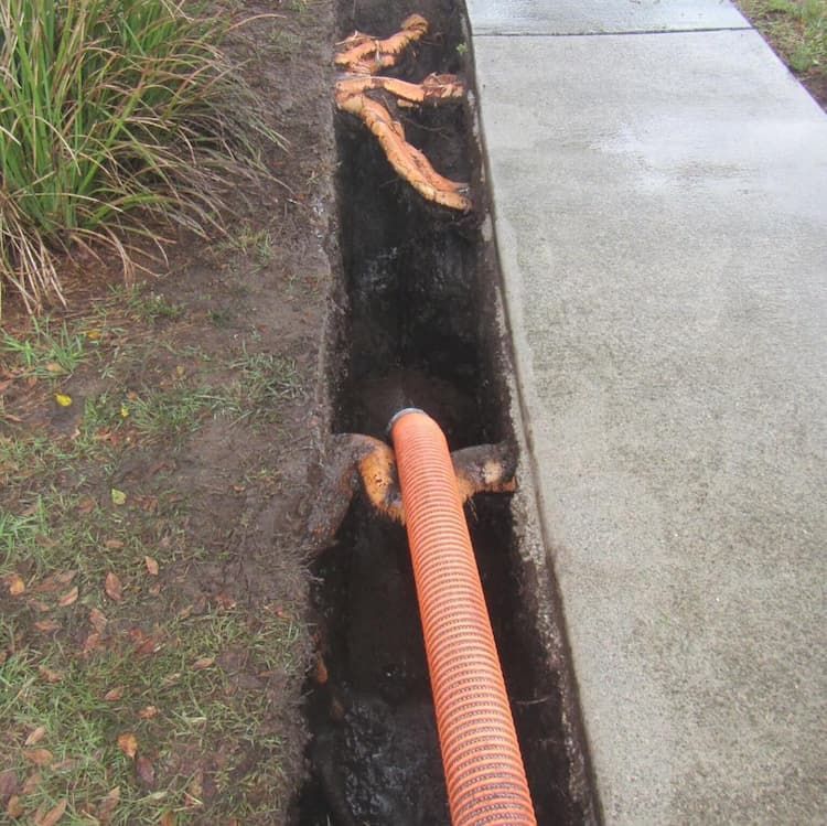 Open Drainage Ditch with Orange Hose — Vacuum Excavation in North Lakes, QLD