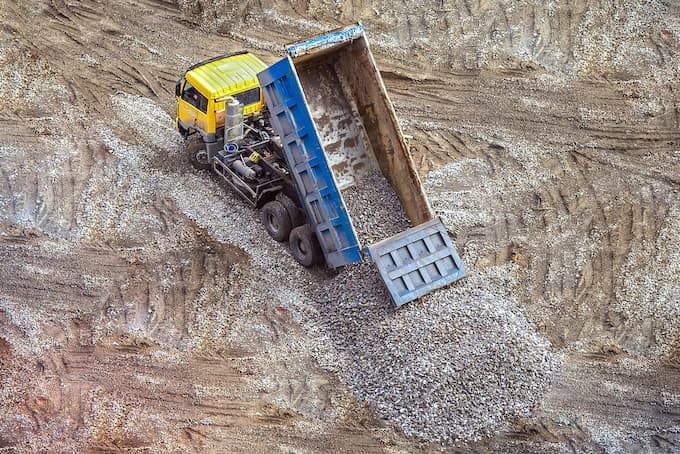 Tipper Truck Unloading Gravel on Construction Site — Vacuum Excavation in Hervey Bay, QLD