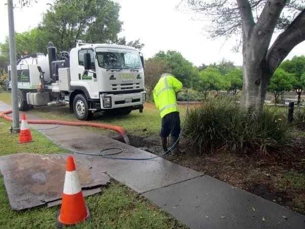 Hydro Excavation Hose Fed Into a Ditch for Water Removal — Hydro Excavation on the Sunshine Coast, QLD