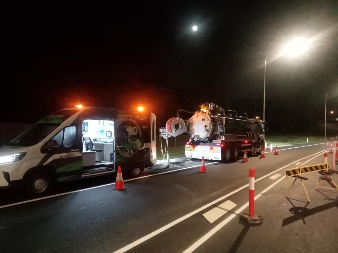 Two Trucks Are Parked On The Side Of The Road At Night — Vacuum Excavation in Sunshine Coast, QLD