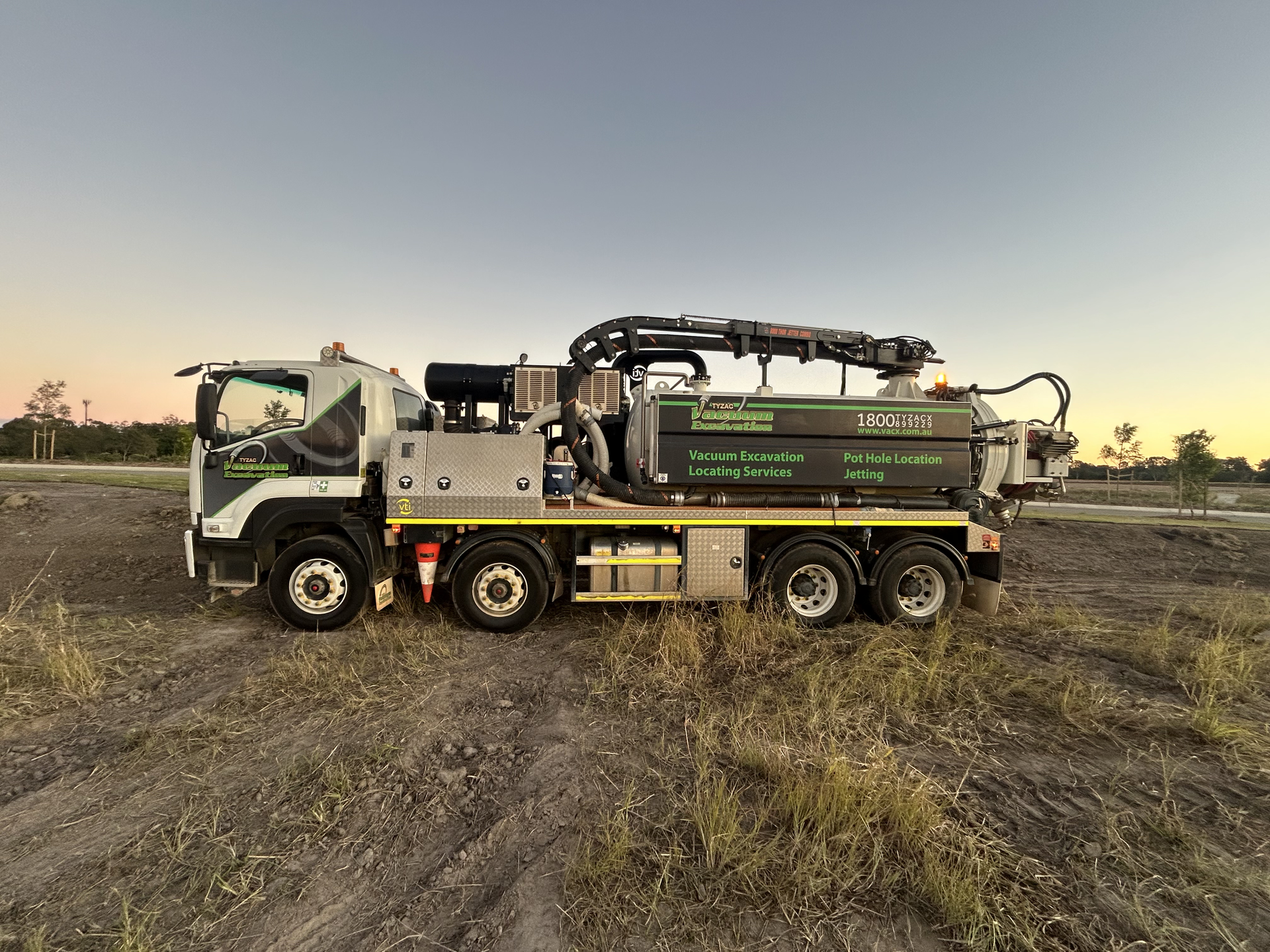A Vacuum Truck Is Parked In A Dirt Field — Tyzac Vacuum Excavation in Sunshine Coast, QLD