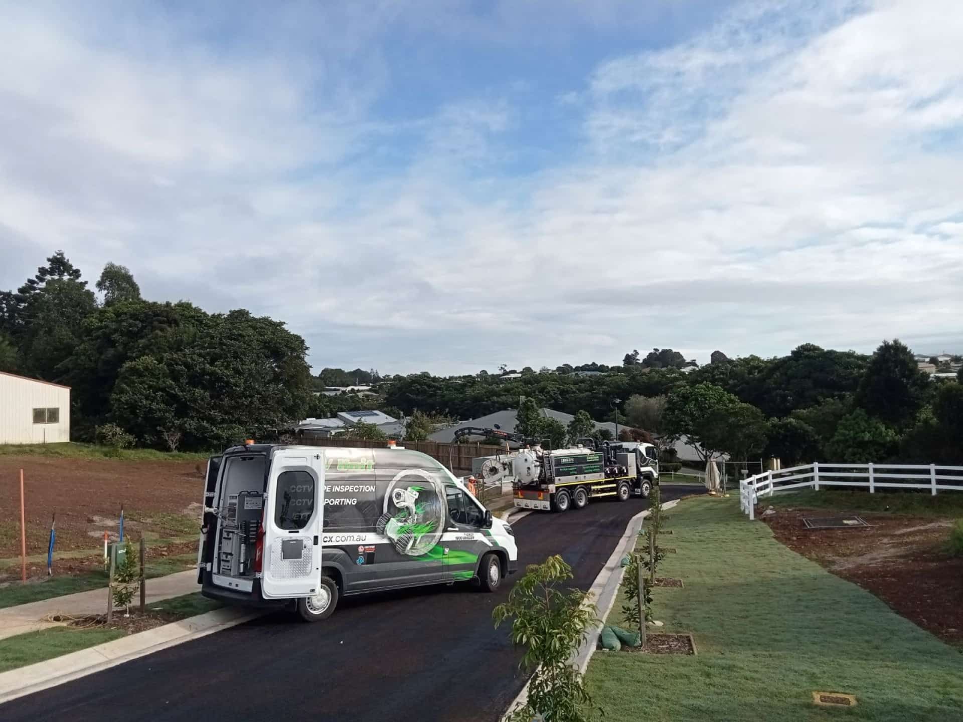 Two Work Vehicles Are Parked on a Newly Paved Road