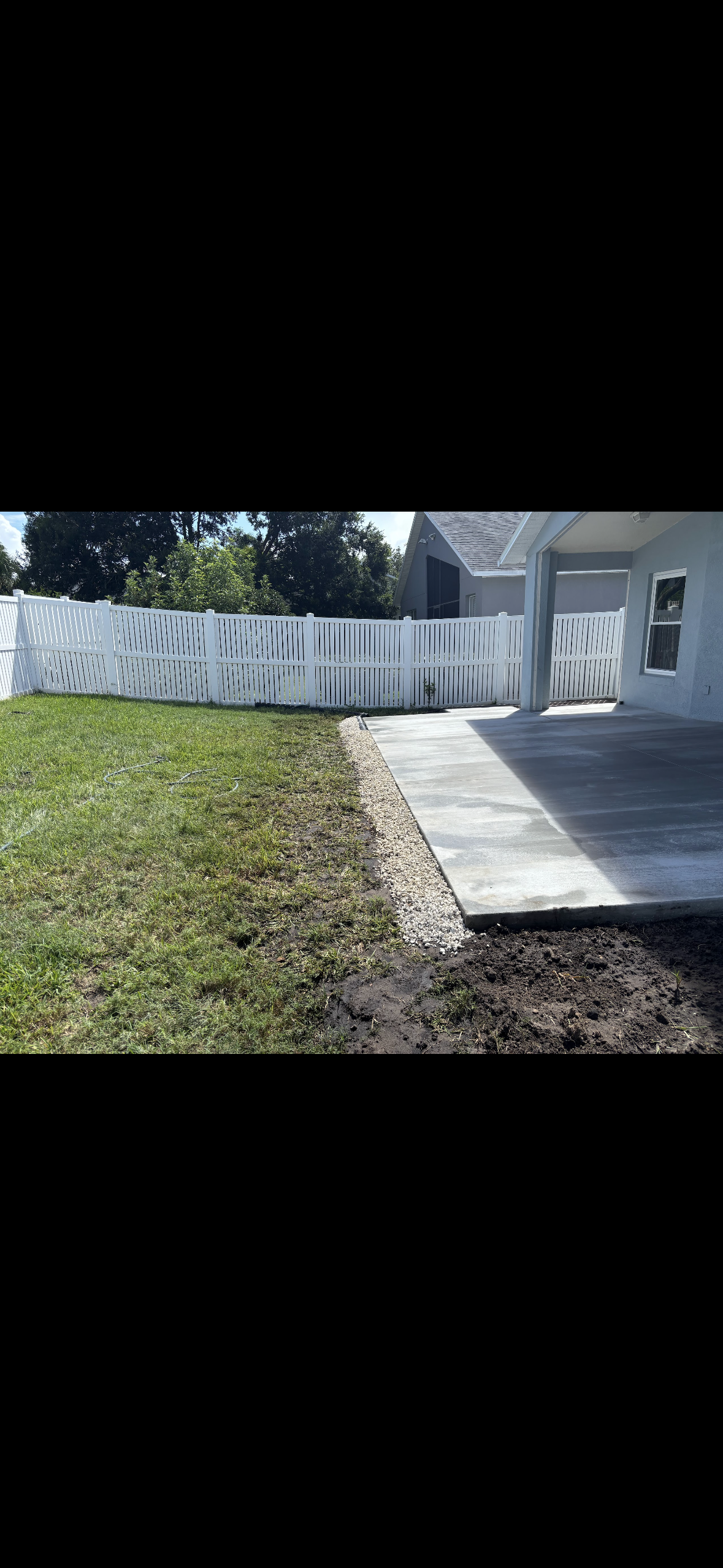 Metal drain along a brick walkway and grassy lawn.