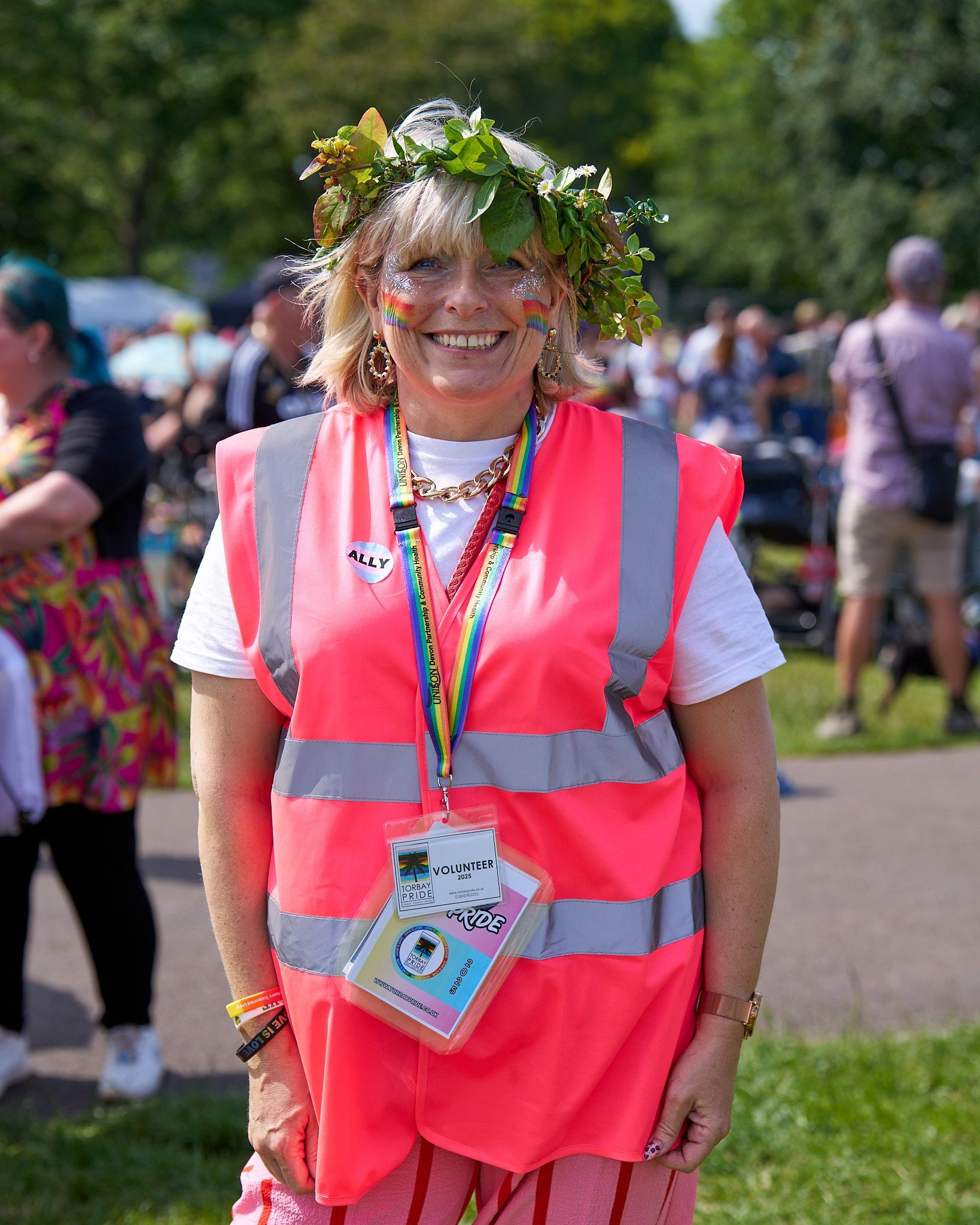 A Drummer playing on stage, wearing a purple hat and sunglasses, holding one drumstick in the air.
