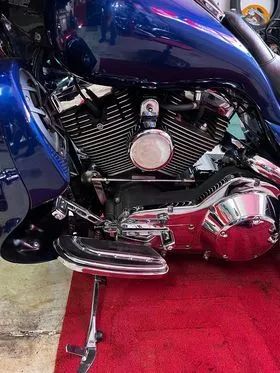 A blue harley davidson motorcycle is parked on a red carpet.