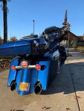 A blue motorcycle is parked on the side of the road.