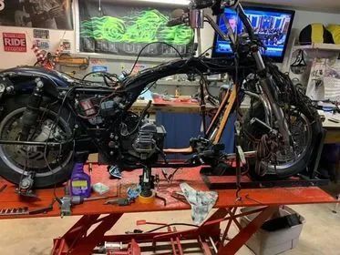 A motorcycle is sitting on a lift in a garage.
