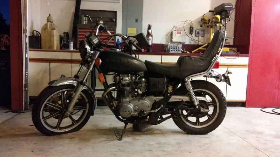 A black motorcycle is parked in a garage