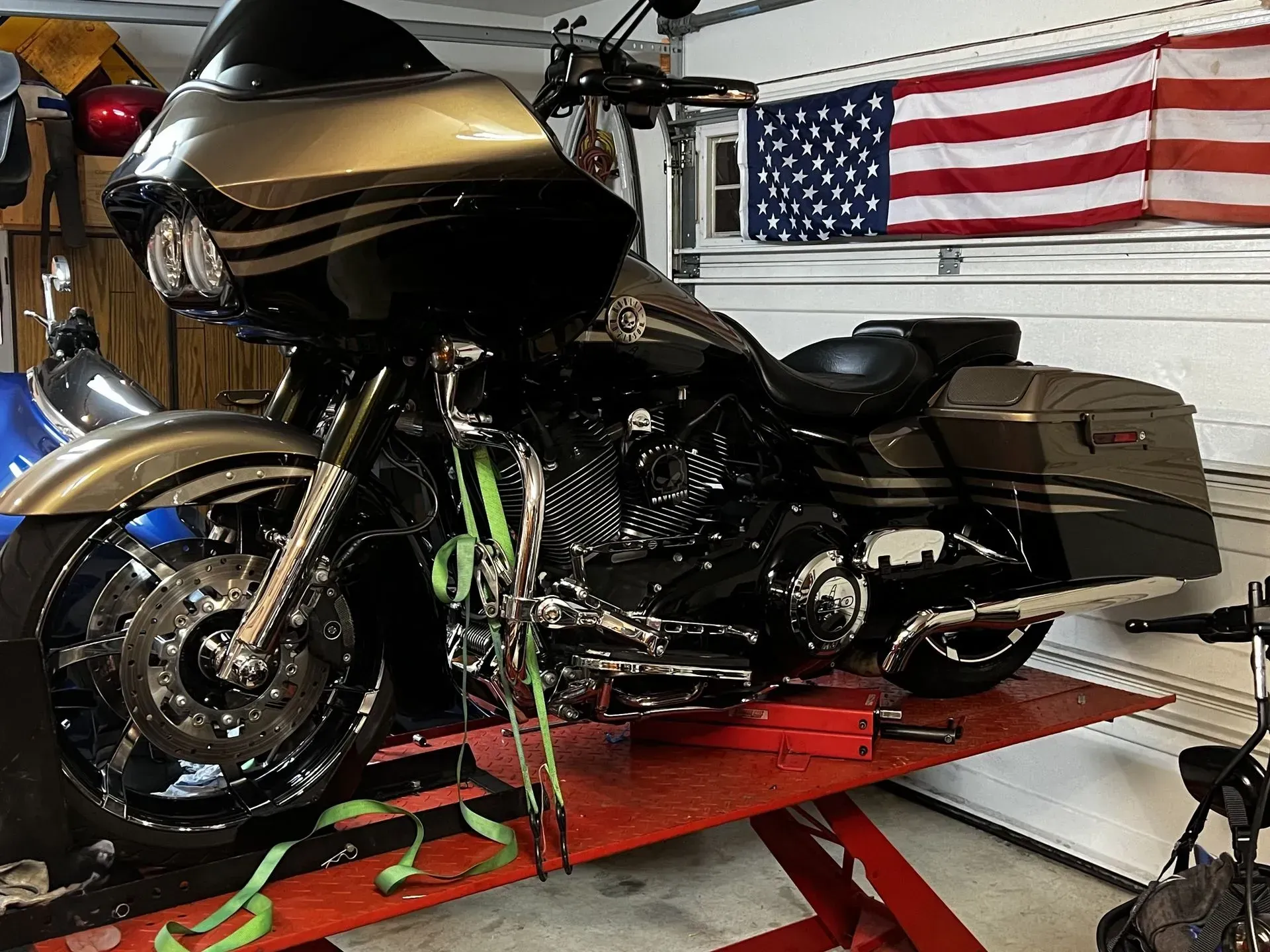 A harley davidson motorcycle is sitting on a lift in a garage.