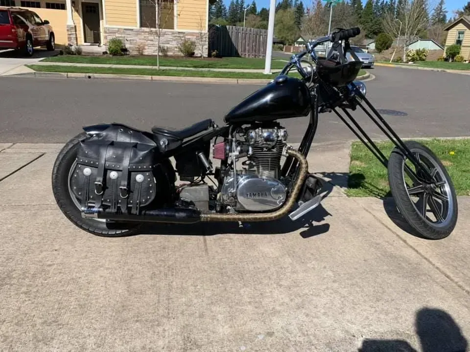 A black chopper motorcycle is parked on the side of the road