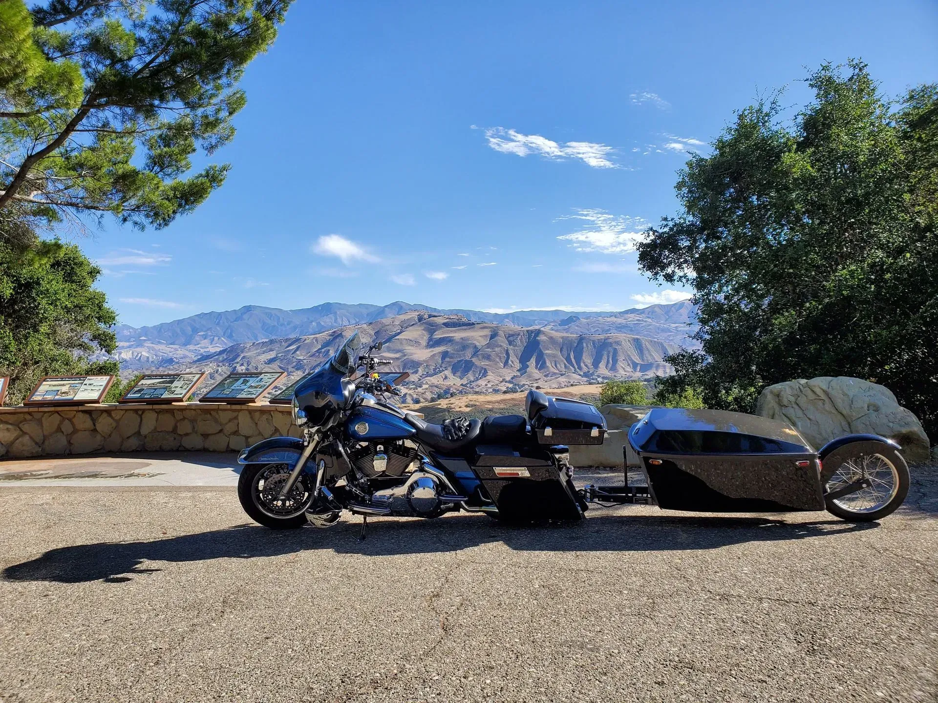 A motorcycle with a sidecar is parked on the side of the road.