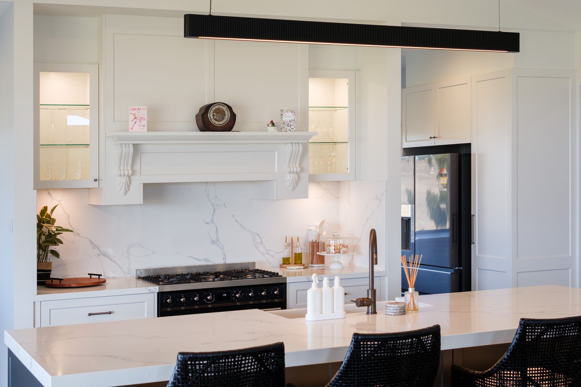 A room with a wooden desk , stools , and a hanging chair.