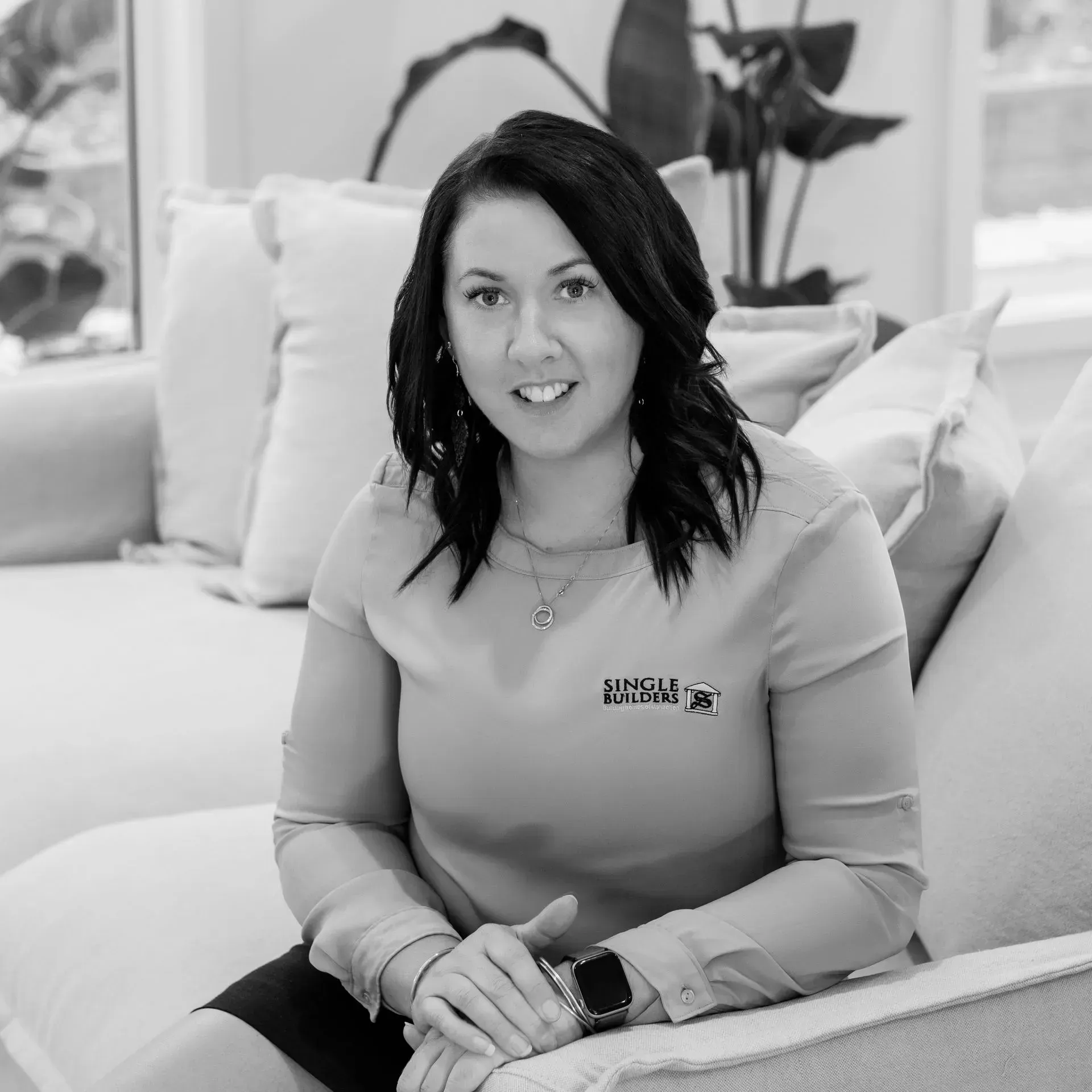 A black and white photo of a woman sitting on a couch.