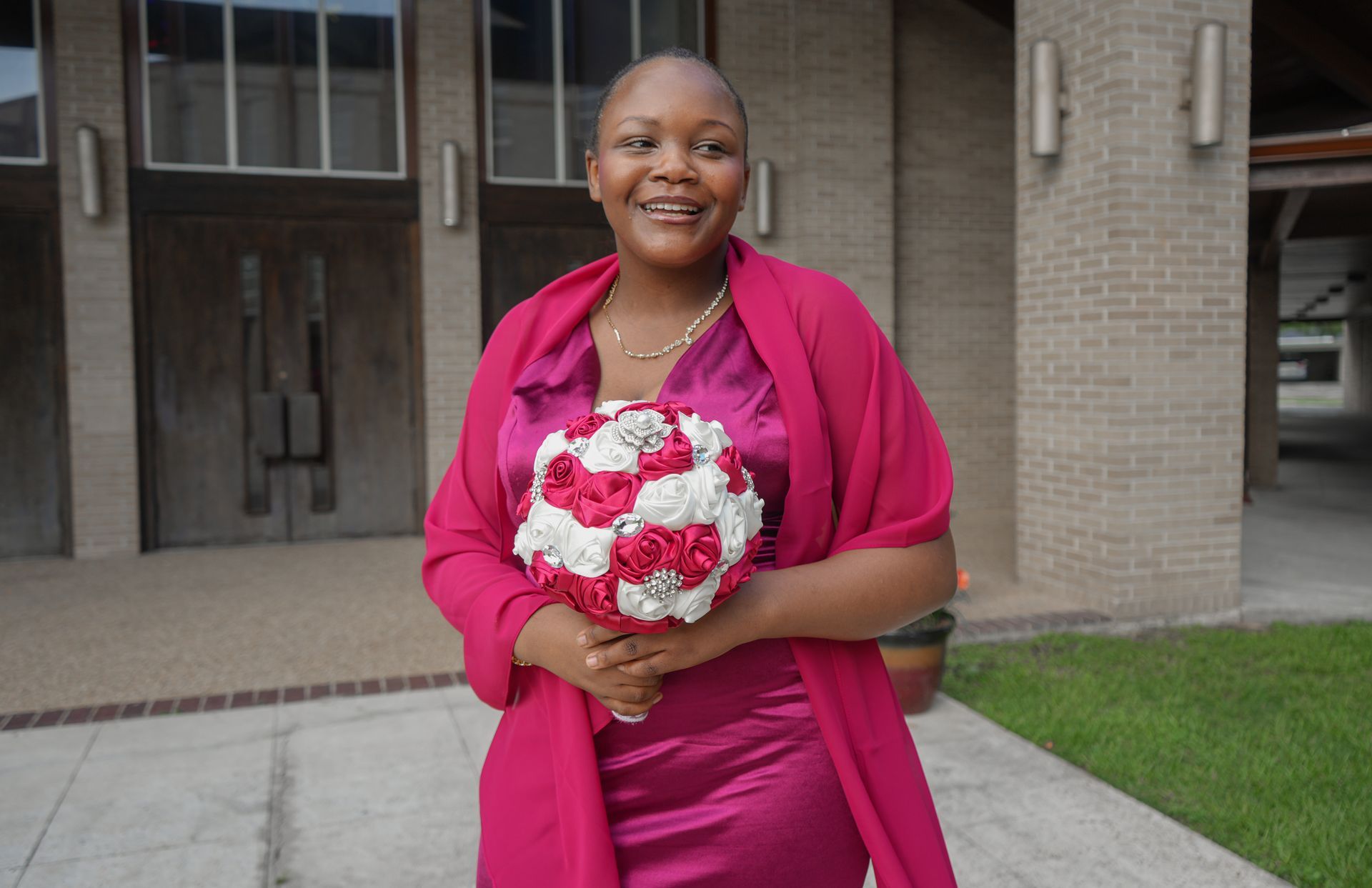A woman in a pink dress is holding a bouquet of flowers.