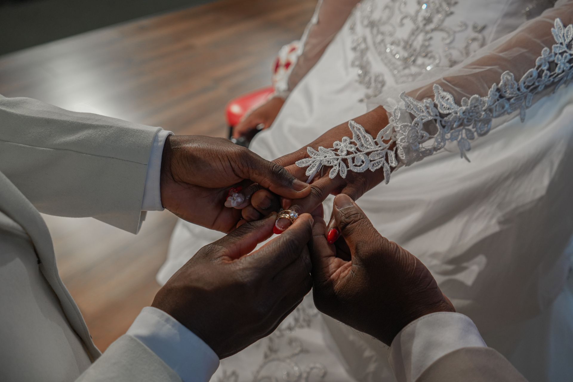 A man is putting a wedding ring on a woman 's finger.