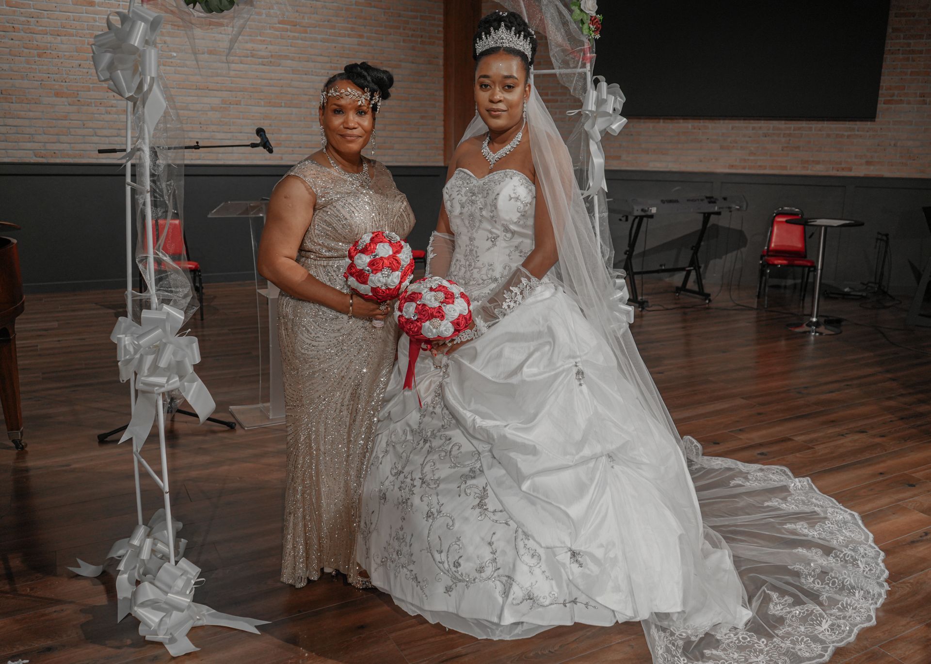A bride and her mother are posing for a picture in a room.