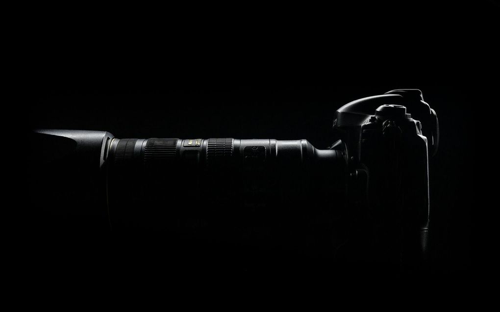 A black and white photo of a camera in the dark.