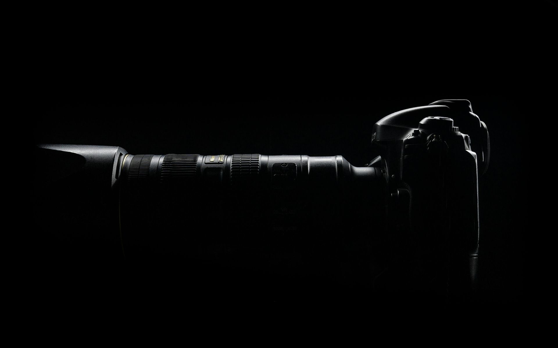 A black and white photo of a camera in the dark.