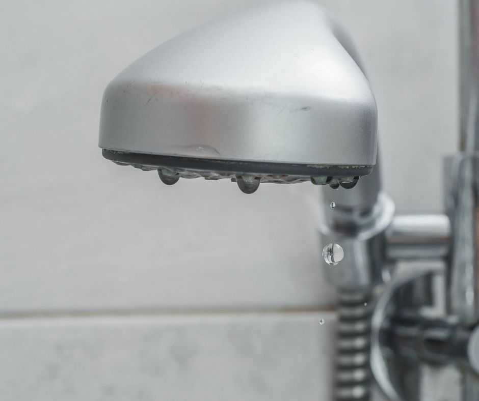 Close-up of a showerhead with a very weak to no water flow at all.