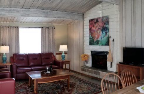 A living room with a couch , table , chairs and a fireplace.