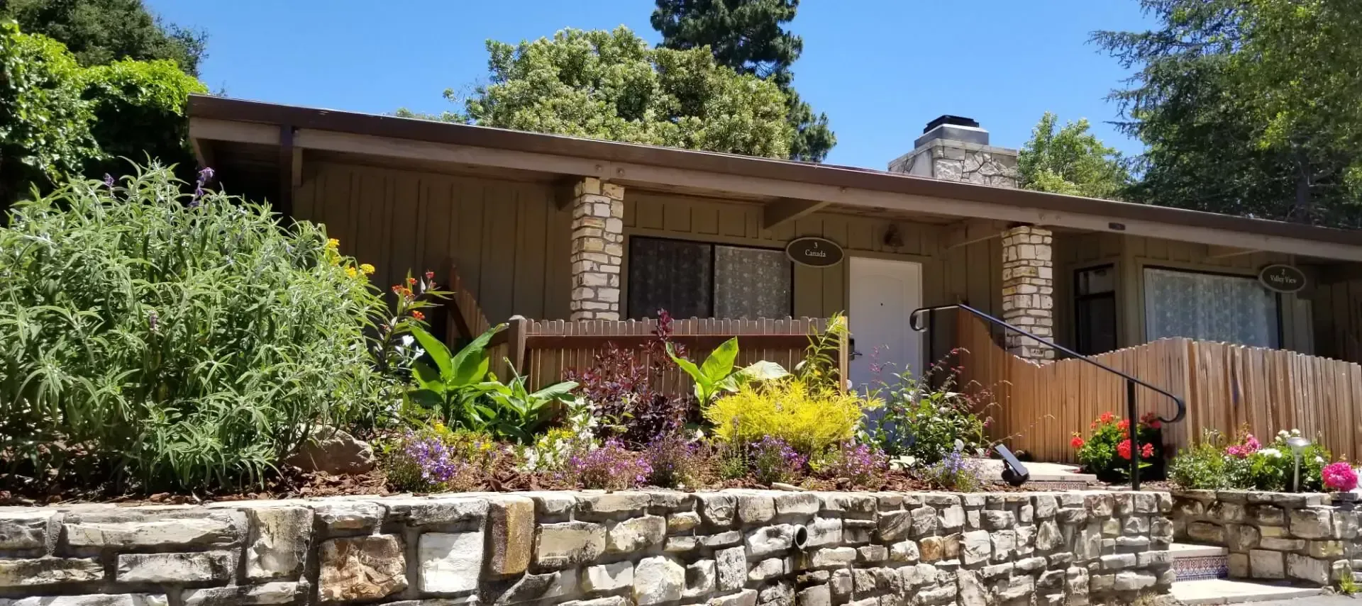 A house with a stone wall in front of it