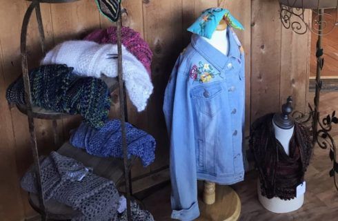 A denim jacket is on a mannequin in a store.