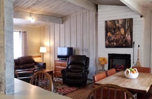 A living room with a table and chairs and a fireplace