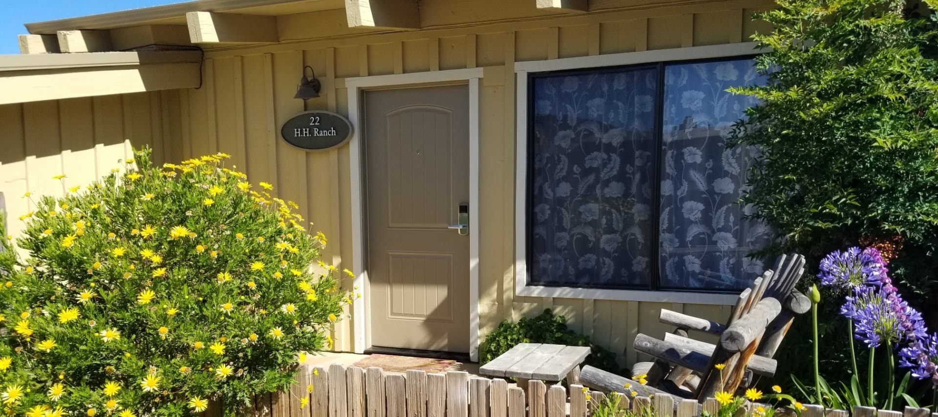 A house with a fence and flowers in front of it