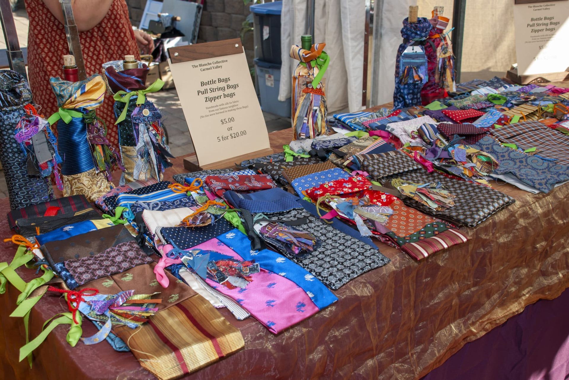 table with colorful fabric sewn into bags to hold bottles, as well as colorful pouches on the table.