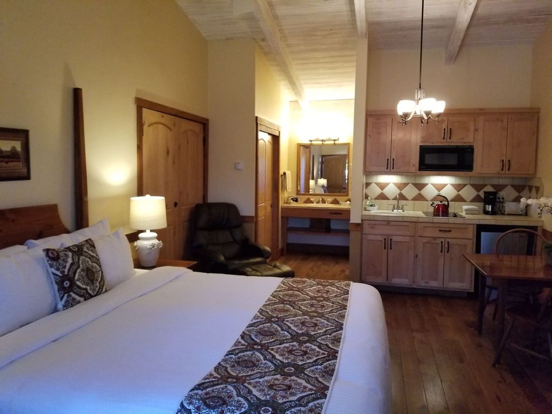 King bed with view of kitchenette and vanity