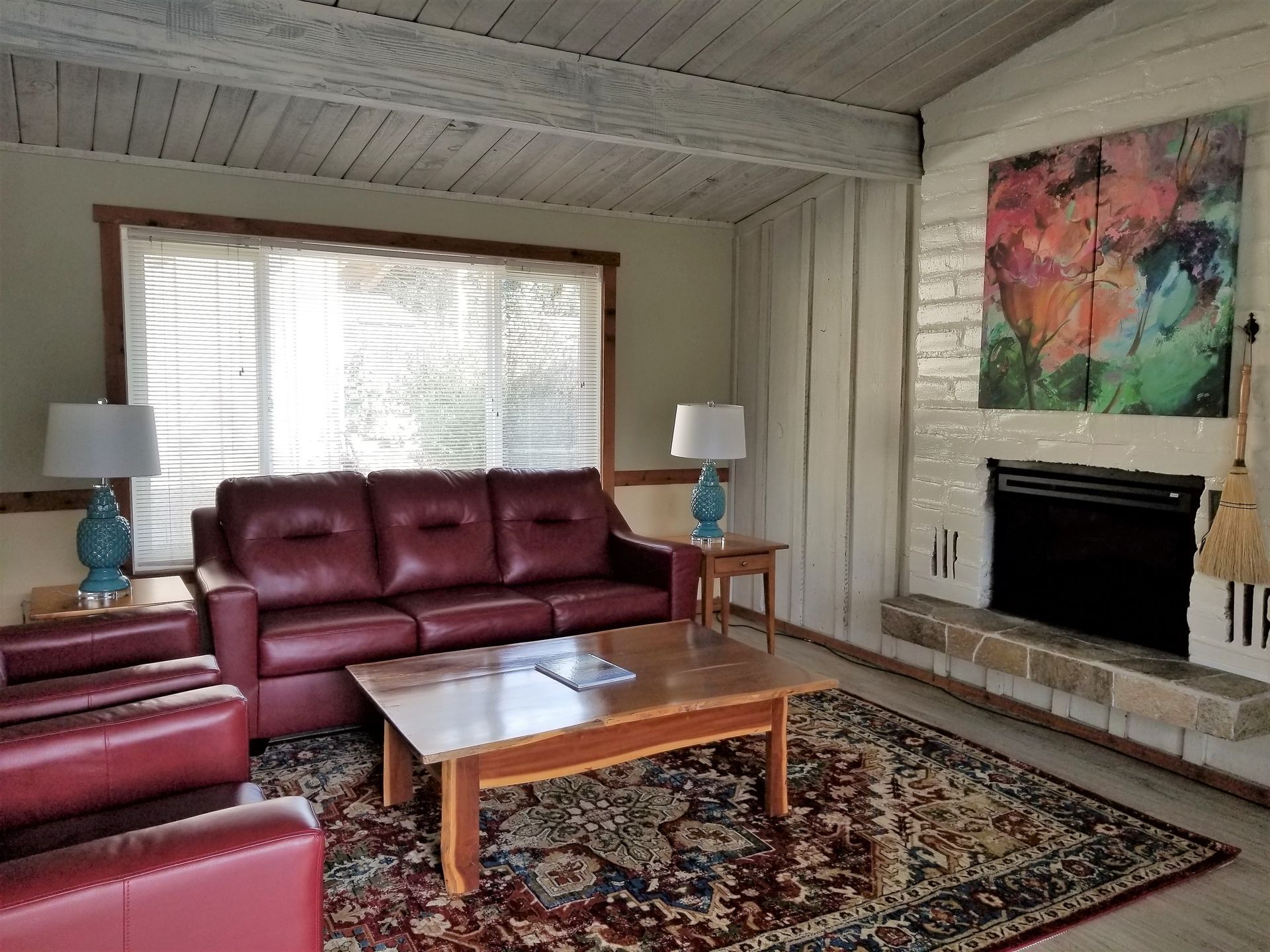 A living room with a red couch and a fireplace