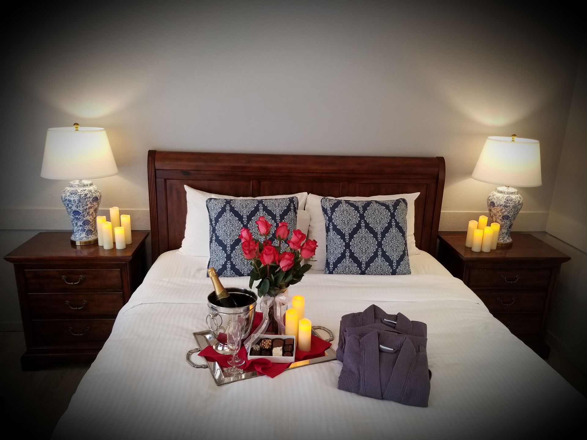 A bed with a tray of food and candles on it