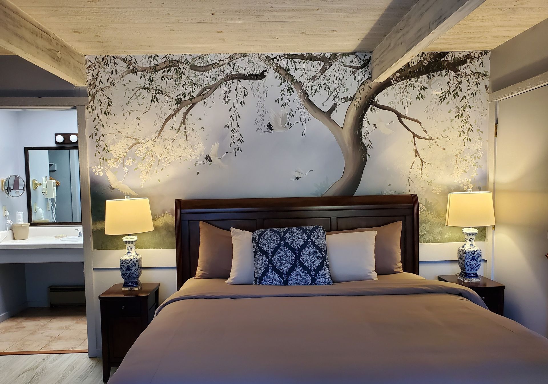 bed head board against a mural of a tree