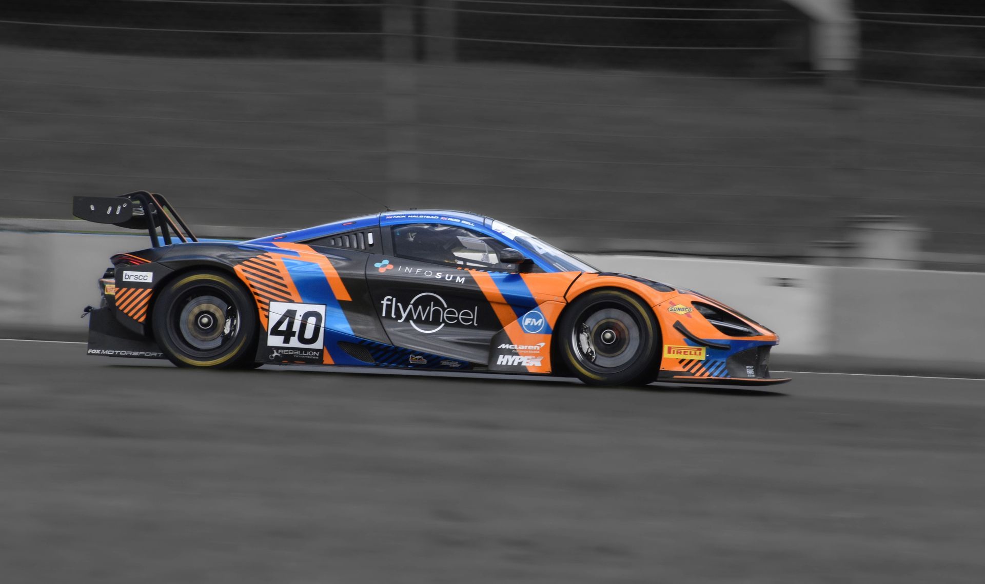 Race car #40, orange and blue, racing on track.