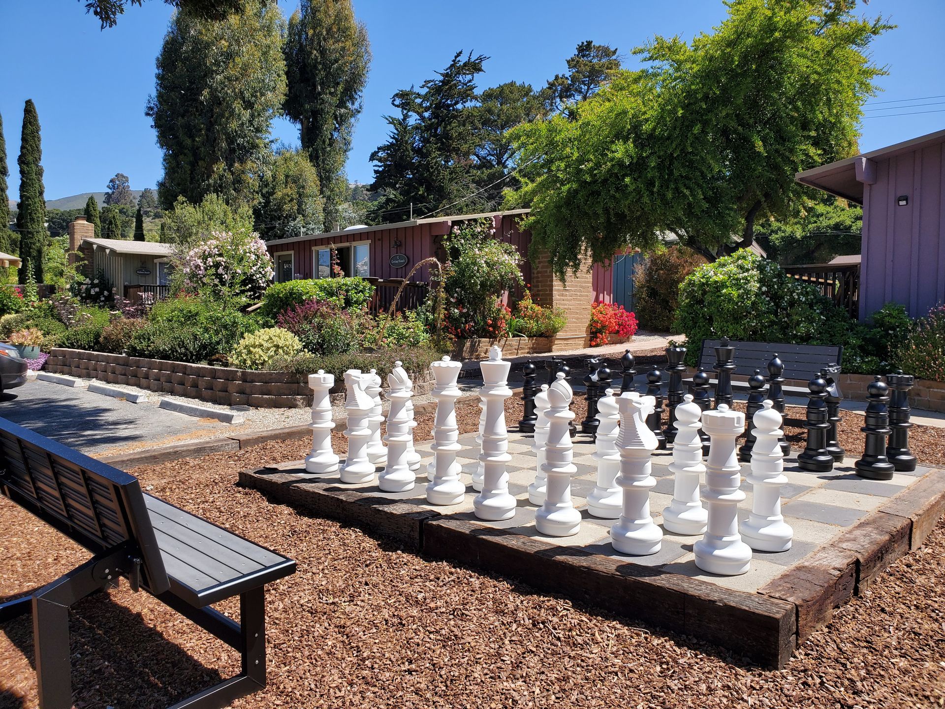 A large chess board with a bench in the background