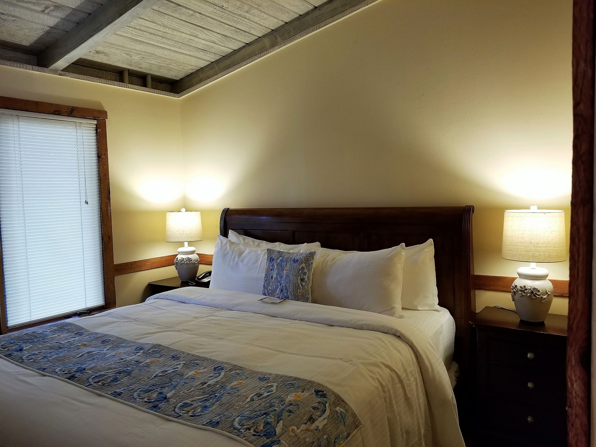 A hotel room with a king size bed and two lamps