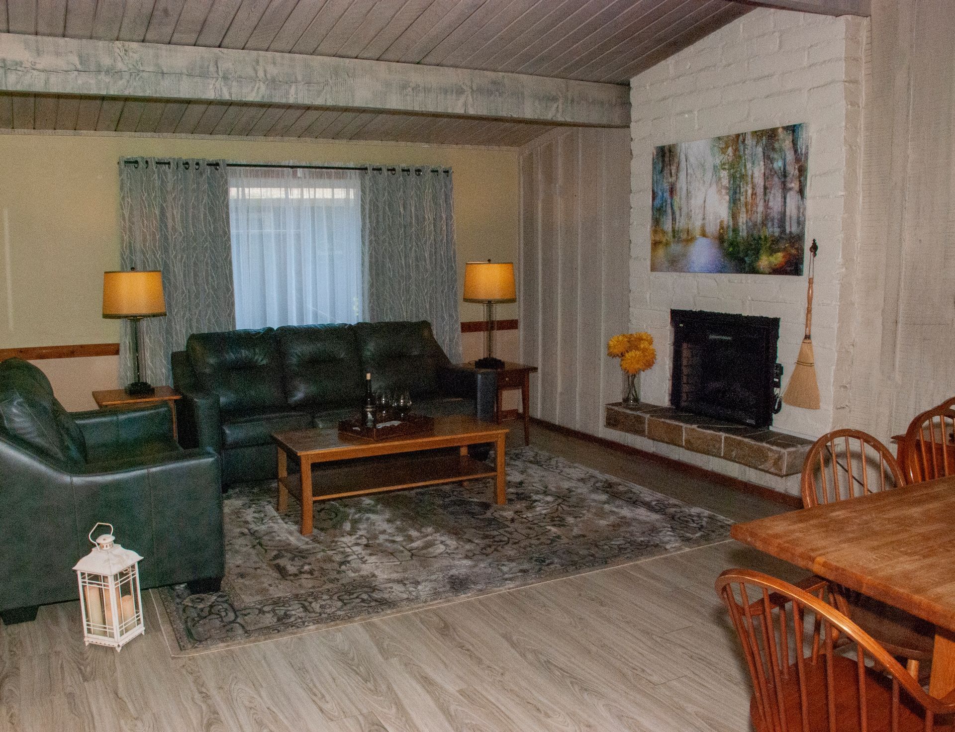 A living room with a couch , chair , table and fireplace