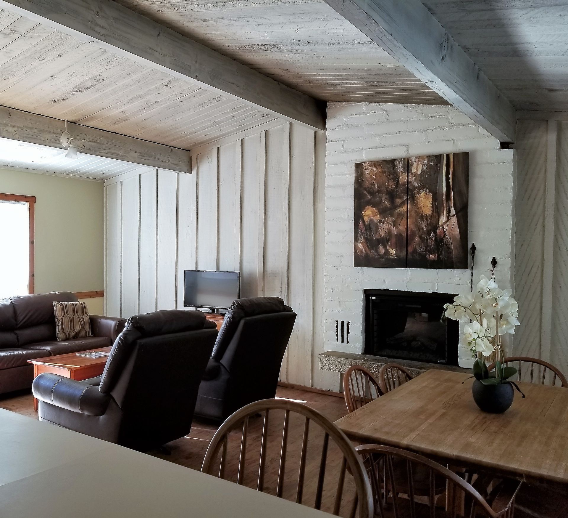A living room with a table and chairs and a fireplace