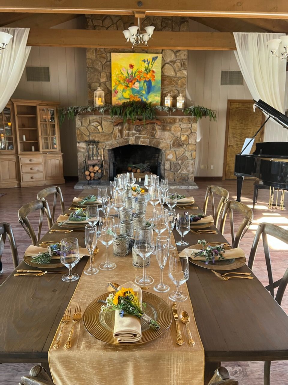A long table with plates and glasses on it in a room with a fireplace.