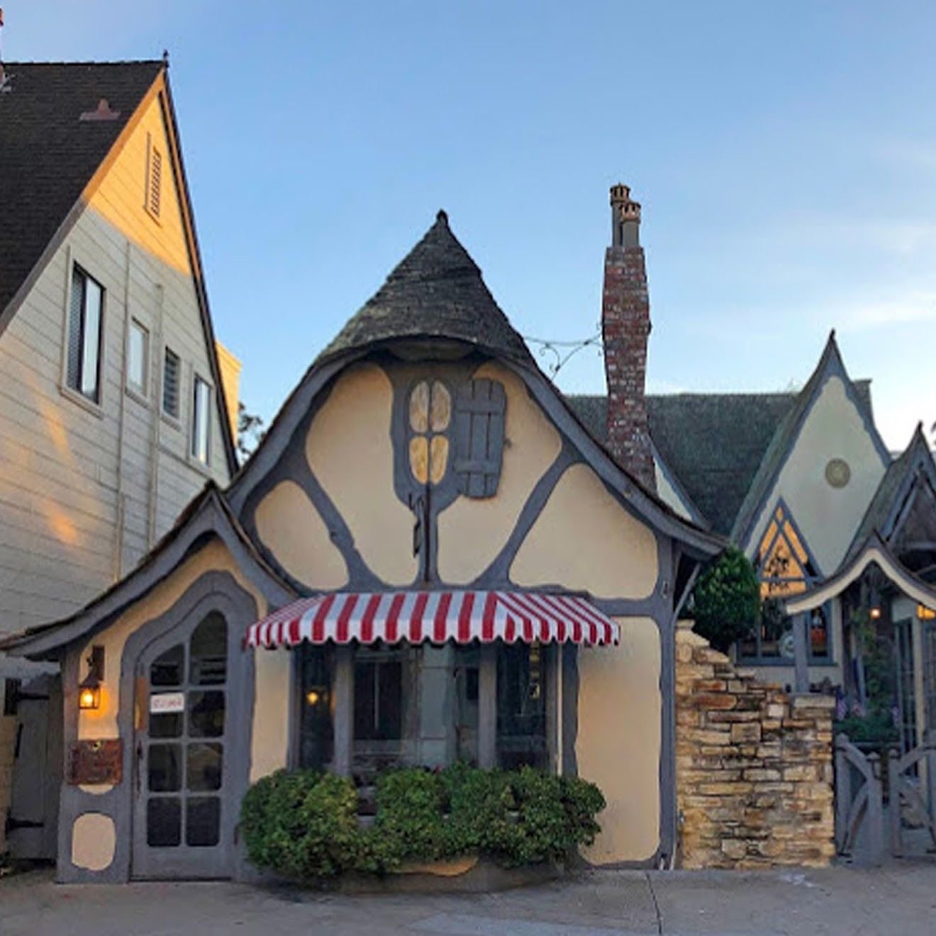 A small house with a striped awning on the front