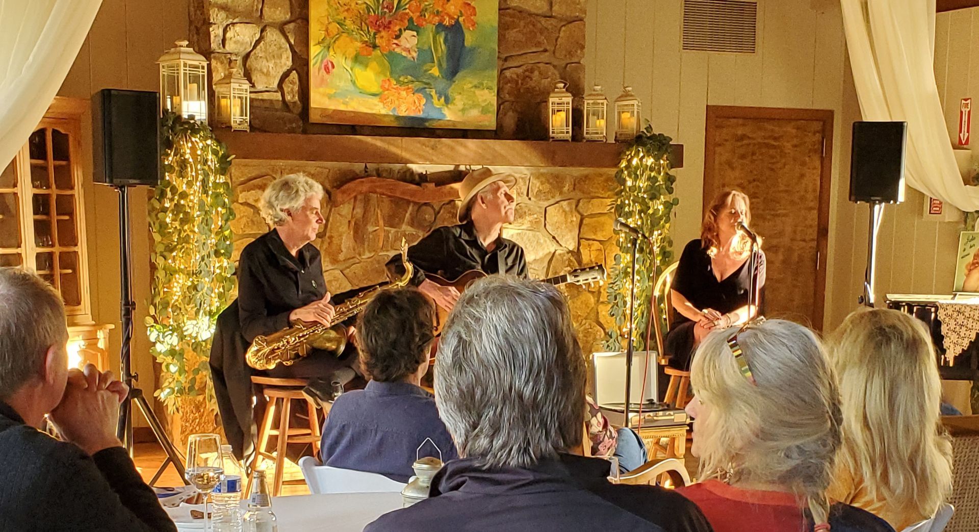 A group of people are sitting in a room watching a band perform.