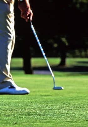 Golfer lining up to putt.