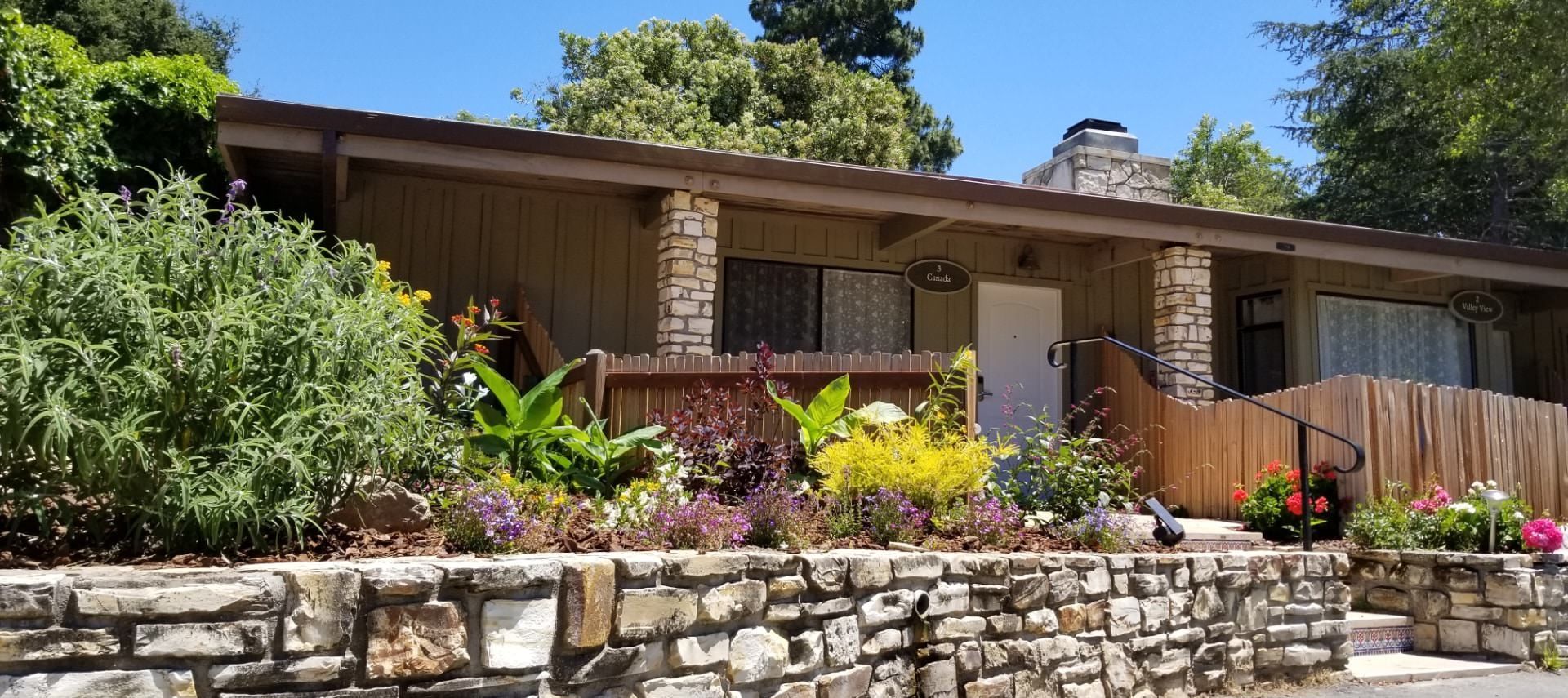 A house with a stone wall in front of it