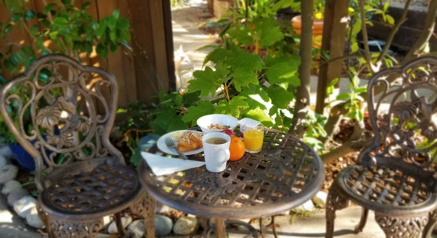 A table with two chairs and plates of food on it.